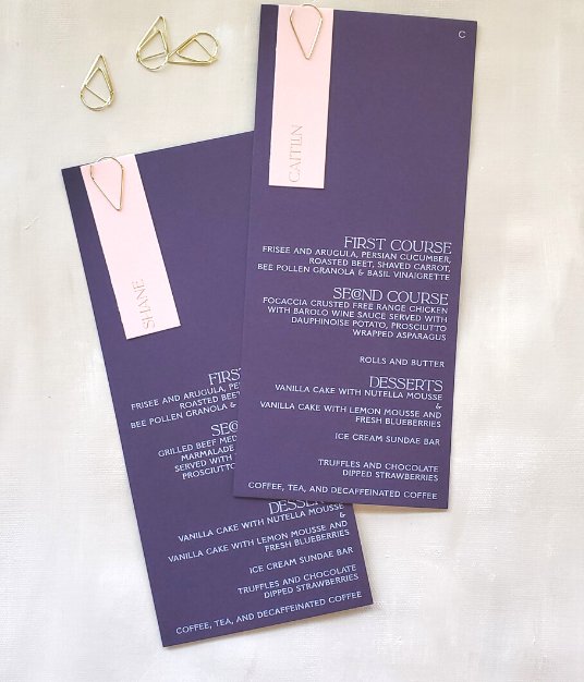 purple menu with white ink and pink place card with gold ink and gold hardware